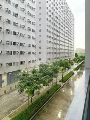 a view of a building with trees in front of it at Warm Retreat with Balcony at Shore 2 Residences in Manila