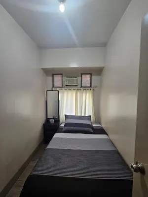 a small bedroom with a bed and a window at Little Baguio Terraces in Manila