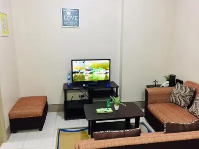 a living room with a couch and a tv at Little Baguio Terraces in Manila
