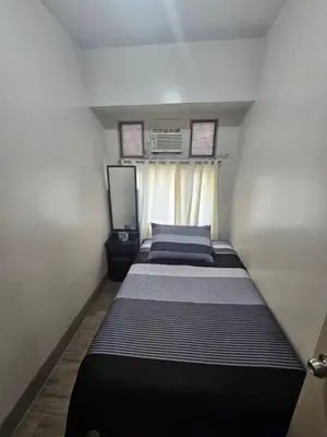 a small bedroom with two beds in it at Little Baguio Terraces in Manila