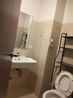 a bathroom with a sink and a toilet at Paseo de Roces Condominium in Manila