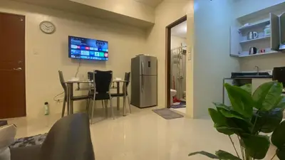 a living room with a table and a refrigerator at 2 Bedroom Premium Condominium Beacon Makati in Manila
