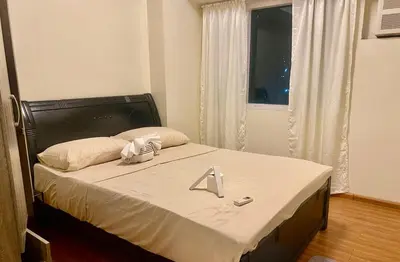 a bed with a white sheet on it in a room at 2 Bedroom Premium Condominium Beacon Makati in Manila