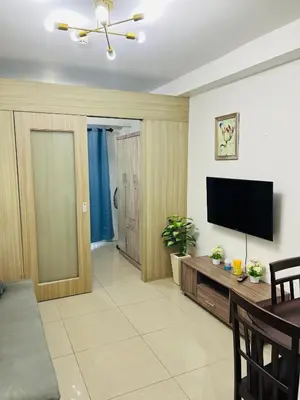 a living room with a flat screen tv on a wall at ESY Condotel shore 1-B in Manila