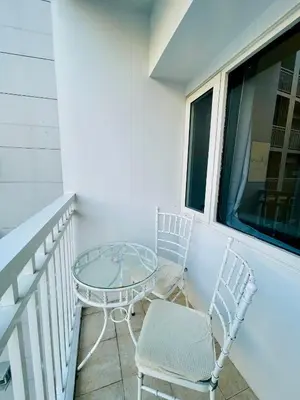 two chairs and a glass table on a balcony at AC Haven in Shore Residences near MOA Pasay City in Manila