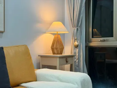 a lamp sitting on a table next to a chair at Premier 3BR with Fast Internet near High Street BGC in Manila