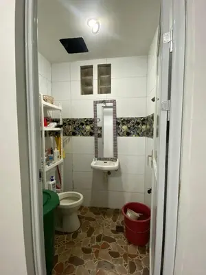 a bathroom with a toilet and a sink and a mirror at Upzora in Manila