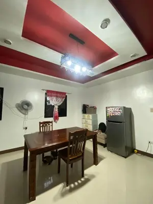 a dining room with a table and a refrigerator at Upzora in Manila