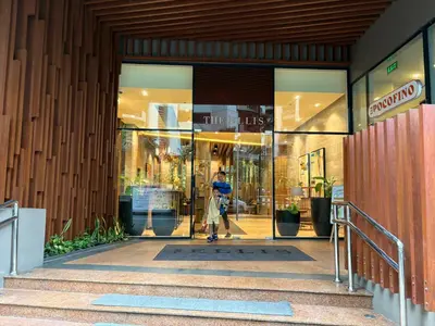 a person walking out of a store door at The Ellis Luxe Suites in Manila