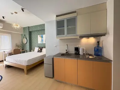 a room with a bed and a kitchen with a bed gmaxwell gmaxwell gmaxwell at The Ellis Luxe Suites in Manila
