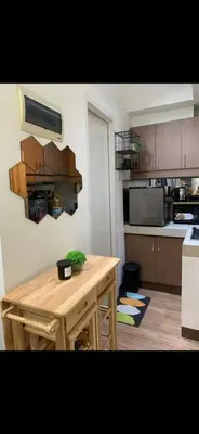 a kitchen with a wooden table in a kitchen at Essel s Comfy Place in Manila