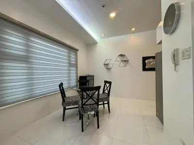 a dining room with two chairs and a table and a window at 8 Adriatico Condominium in Manila