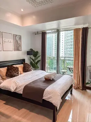 a bedroom with two beds and a large window at Casa Del Sol in Manila