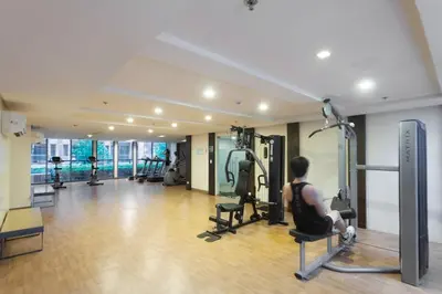a person sitting on a chair in a gym at Klassi Executive Stay near NAIA in Manila