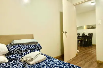 a bedroom with two beds and a dining room at Chic Getaway Near Airport in Manila