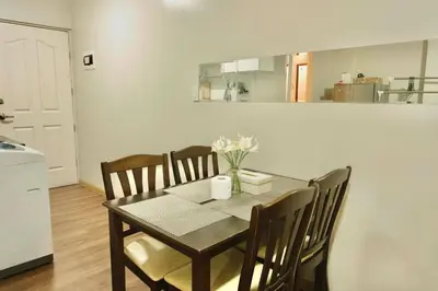 a dining room with a table and chairs and a kitchen at Chic Getaway Near Airport in Manila
