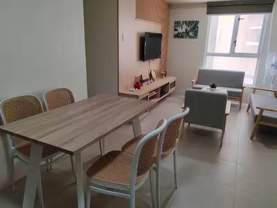 a dining room with a wooden table and chairs at Chic Getaway in Sucat in Manila