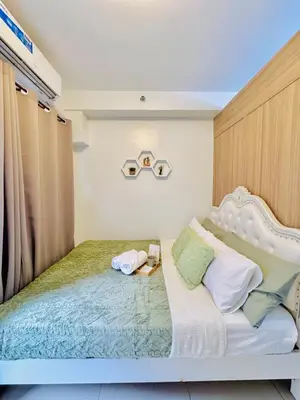 a bedroom with a white bed with a headboard at 1 Bedroom Unit near MOA & NAIA Terminal in Manila