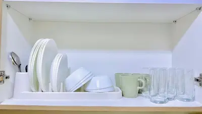 a white tray with plates and glasses on a shelf at 1 Bedroom Unit near MOA & NAIA Terminal in Manila