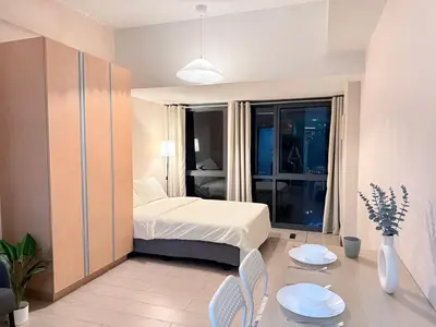 a bedroom with a bed and a table and chairs at Cozy Studio in Salcedo Village Makati City in Manila