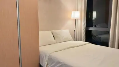 a bedroom with a bed with white sheets and pillows at Cozy Studio in Salcedo Village Makati City in Manila