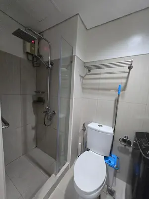 a bathroom with a shower and a toilet and a glass shower at J&W Homestay in Manila