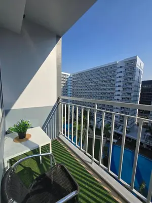 a balcony with a table and a view of a building at J&W Homestay in Manila