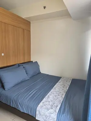 a bedroom with a bed with blue pillows at J&W Homestay in Manila