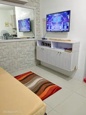 a living room with a tv on a wall at Balai Staycation in Imus
