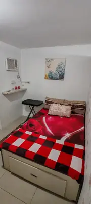 a bed with a red and white checkered blanket on it at Balai Staycation in Imus