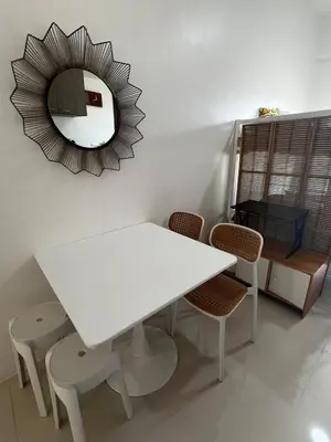 a white table with chairs and a mirror on the wall at Modern Studio with Balcony and City View Near BGC in Manila