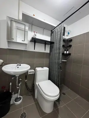 a bathroom with a toilet and a sink at Modern Studio with Balcony and City View Near BGC in Manila