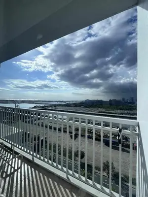 a view of the ocean from a balcony with a fence at Two-Bedroom by Metro Staycation in Manila