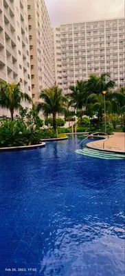 a large blue swimming pool in front of a large building at 2 ROOMS 1 UNIT by Metro Staycation in Manila