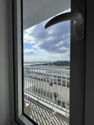 a window with a view of the ocean from a balcony at 2 ROOMS 1 UNIT by Metro Staycation in Manila