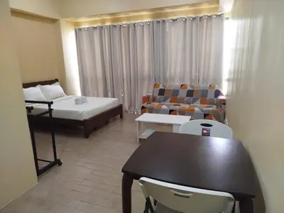 a living room with a couch and a table and chairs at Gambino Homes in Manila
