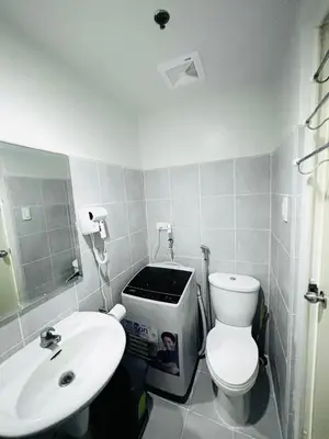 a bathroom with a white toilet and a sink at RE Staycations MOA VIEW in Manila