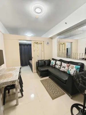 a living room with a black couch and a table at Sea Residence by una in Manila