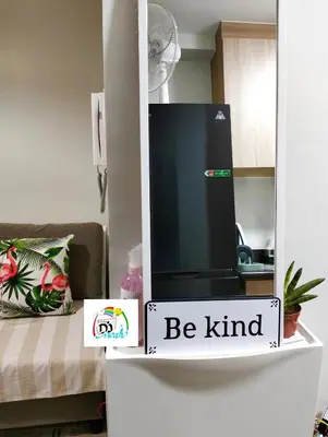 a black refrigerator with a sign that says be kind at Little NOAH in Manila