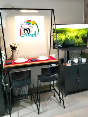 a room with a table and two chairs and a tv at Little NOAH in Manila