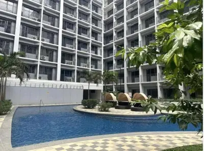 a large building with a swimming pool in front of it at Little NOAH in Manila