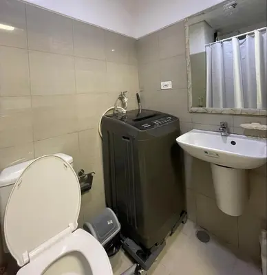a small bathroom with a toilet and a sink at Dayontabalay in Manila