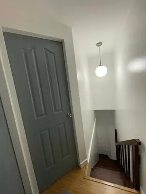 a hallway with a gray door and a staircase at PrimeStay BGC in Manila