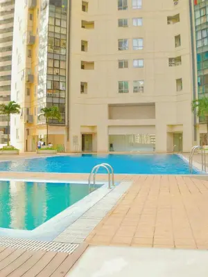 a swimming pool in front of a tall building at PrimeStay BGC in Manila