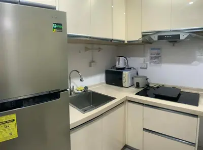 a small kitchen with a sink and a microwave at PrimeStay BGC in Manila