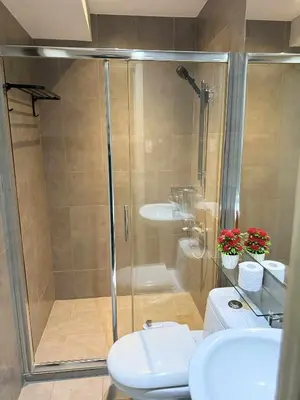 a bathroom with a shower and a toilet and a sink at The Gramercy Residences in Manila