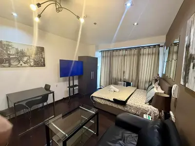 a small room with a bed and a desk at The Gramercy Residences in Manila