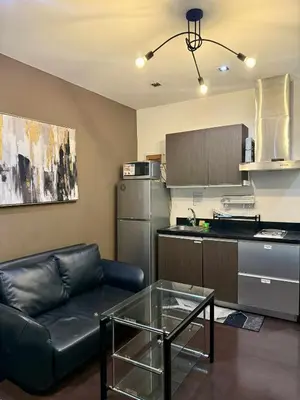 a living room with a couch and a kitchen at The Gramercy Residences in Manila