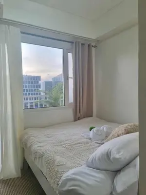 a bedroom with a bed with a large window at 963 D shore 1 in Manila