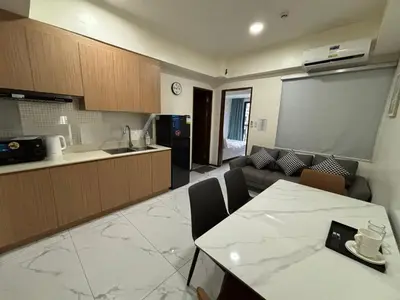 a kitchen and a living room with a table and a couch at Sunnyplace Residences Near NAIA Airport in Manila